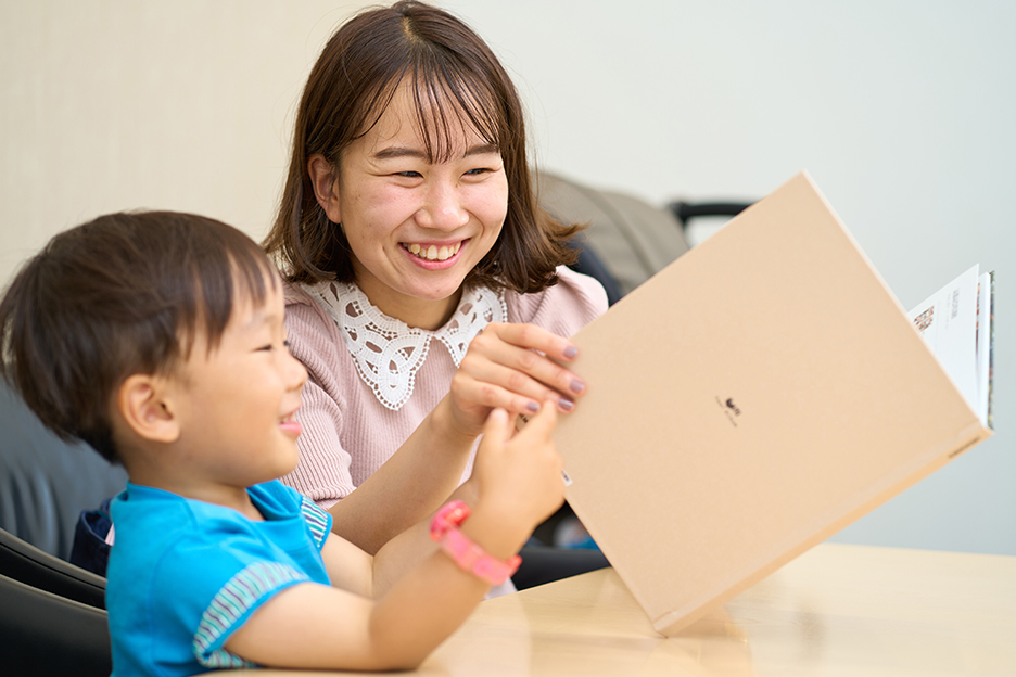 アルバムを見ながらニコニコする佐藤さんのお子さん