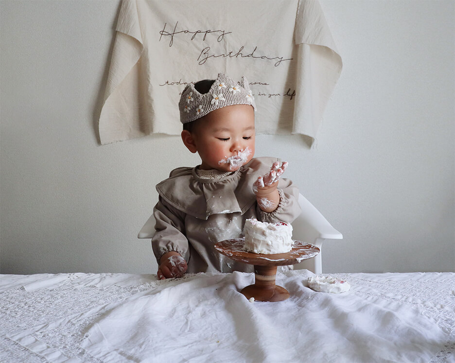 誕生日ケーキを手掴みで食べる幼児