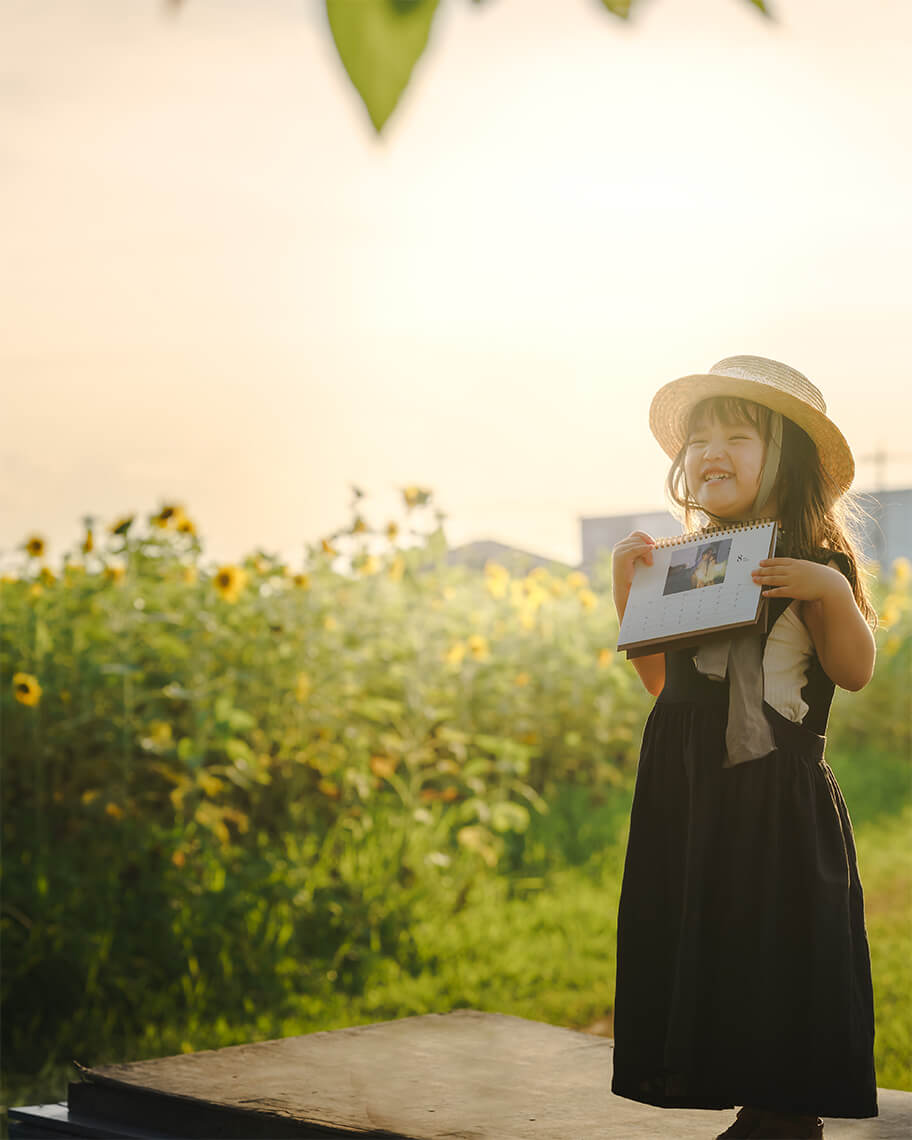 「COYOMI」の「日めくり万年(1か月)の卓上カレンダー」とそれを手に取る子ども
