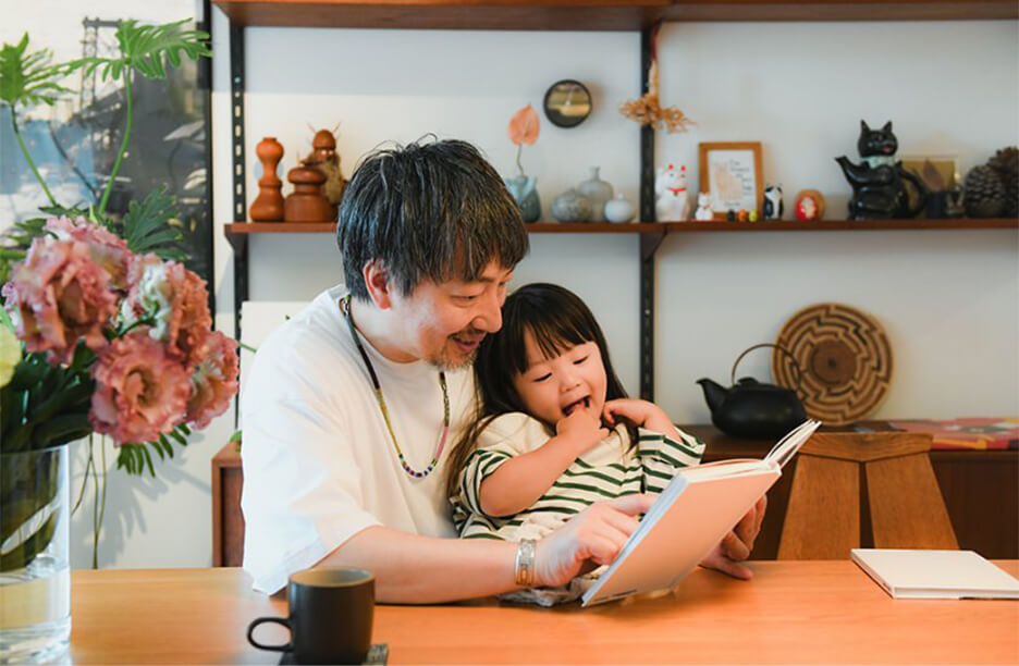 富士フイルムのフォトブック「イヤーアルバム」を親子で読んでいる様子
