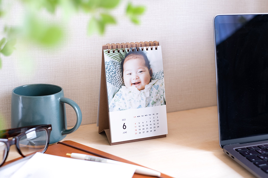 赤ちゃんの写真入りオリジナル卓上カレンダーをデスクに置いている写真