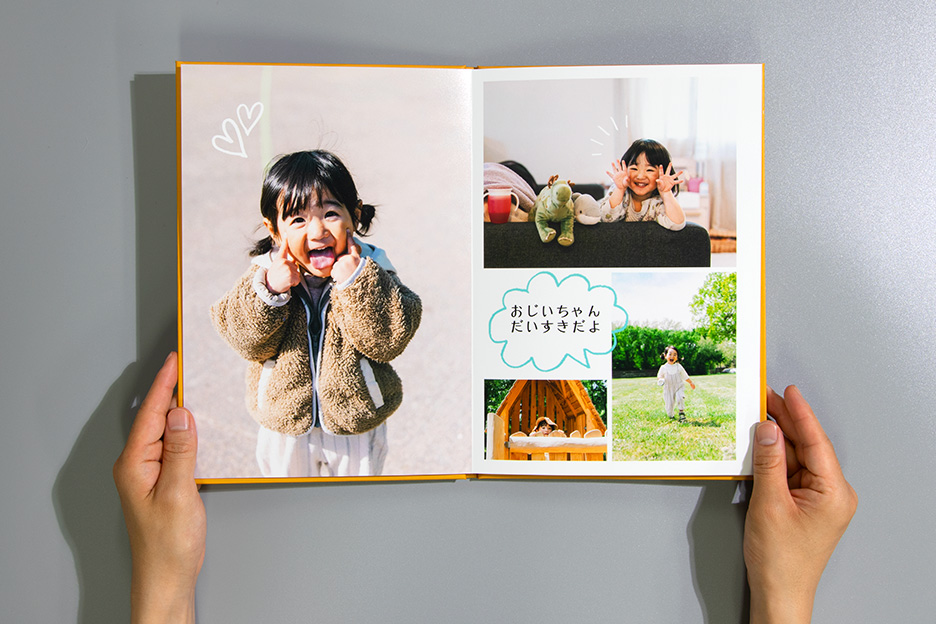 写真を大きめにレイアウトしたフォトブック ハードカバーを、両手で持っている写真