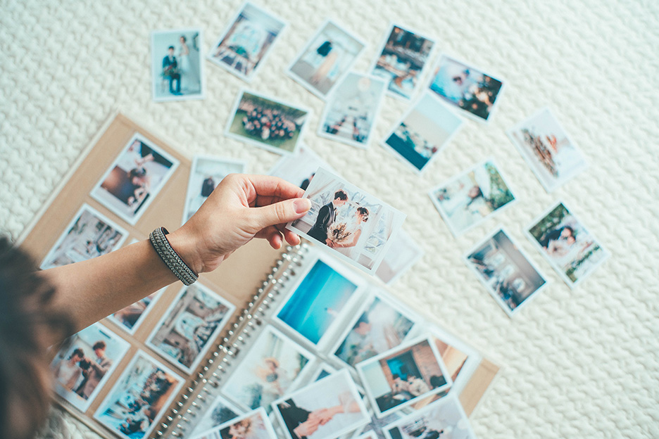 「ハーフサイズプリント」にプリントされた結婚式の写真を並べて、選びながらアルバムに入れている写真