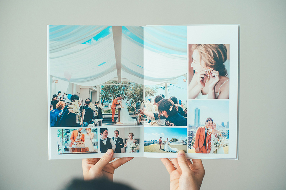 結婚式の写真をプリントした「フォトブック ハードカバー」を開いている写真