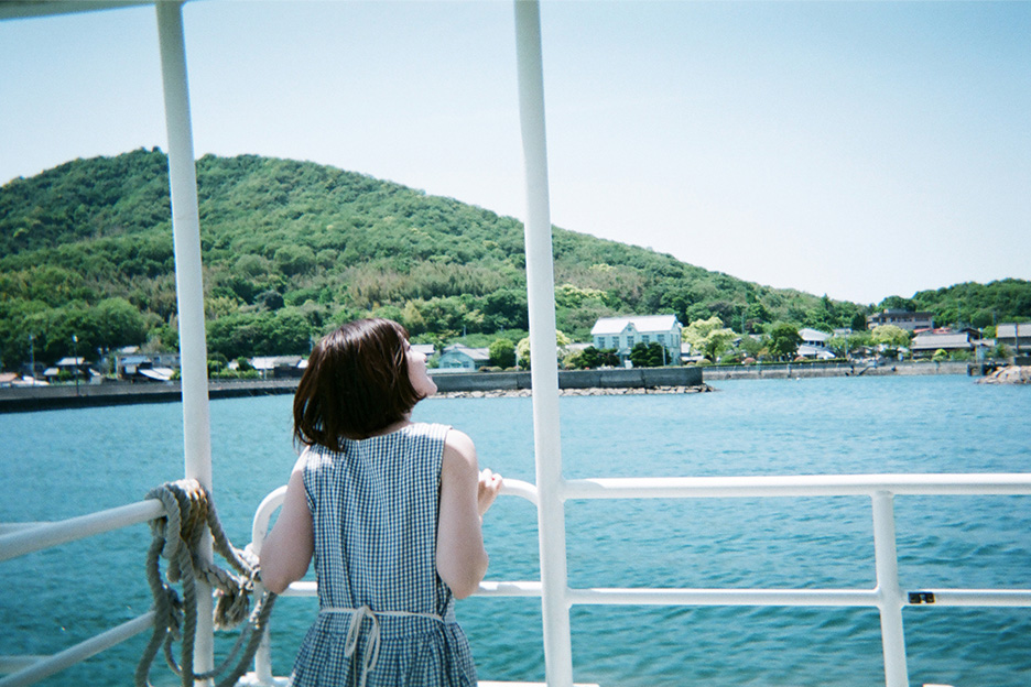 船に乗って景色を眺める女性の写真