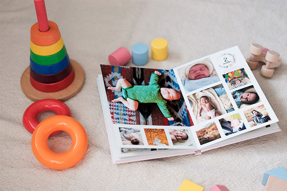 玩具が散らばる中に、子ども写真が掲載されたイヤーアルバムが置かれている写真