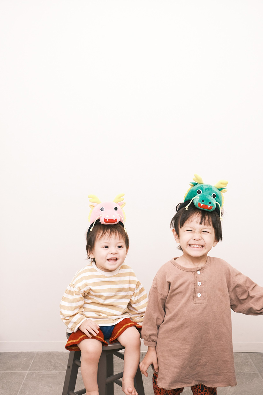 上部に余白を残して撮影した、頭に辰の飾りをつけた子ども2人の写真