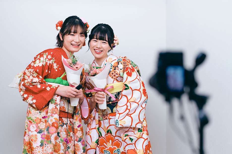 振袖の女性2人が花束を持って撮影している写真
