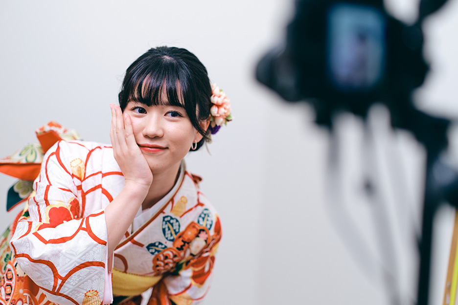 振袖を着た女性が頬に手をあててポージングしている写真
