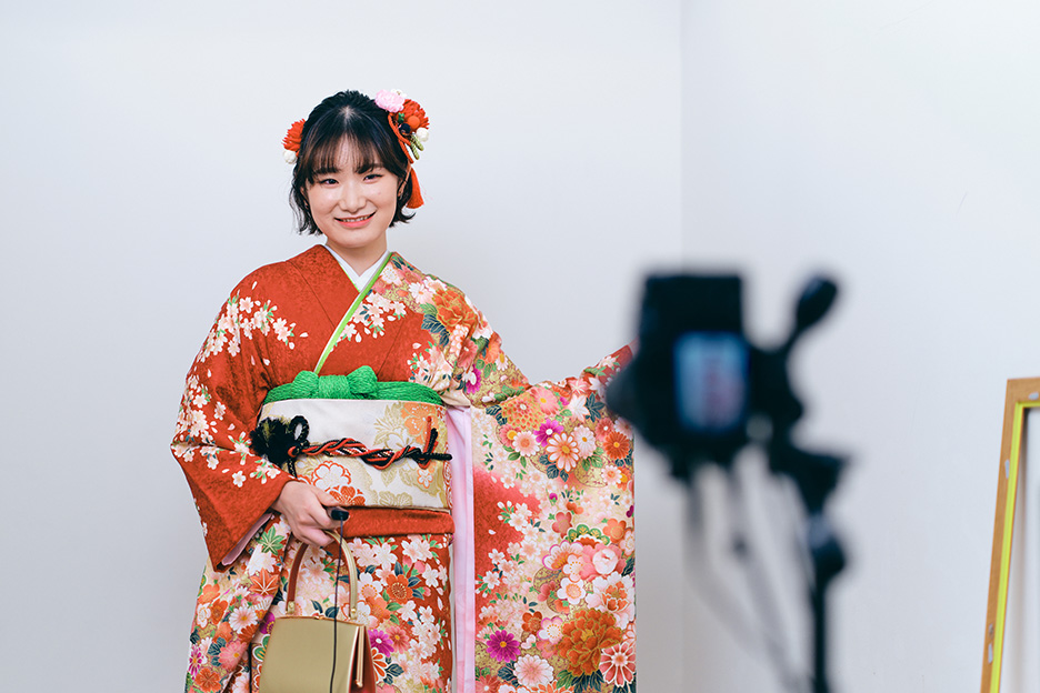 振袖を着た女性が袖を広げてポージングしている写真