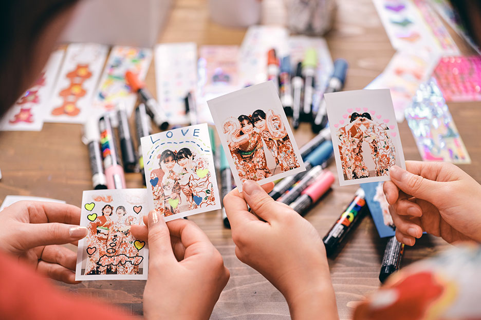 ポスカでデコレーションしたハーフサイズプリントを見比べている写真