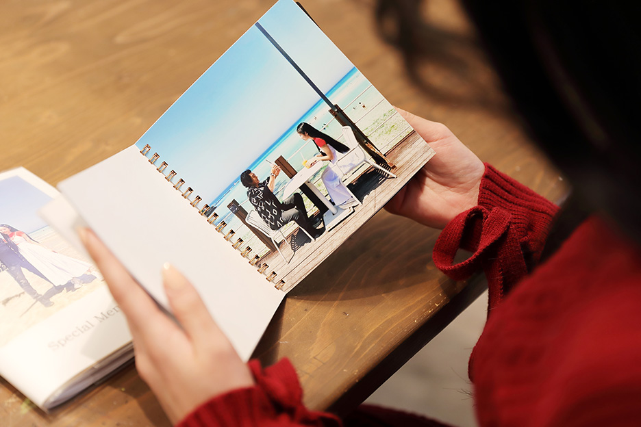 天翔天音さんが親子で行った旅行の写真がプリントされた「フォトブック リング」のページを開いている写真