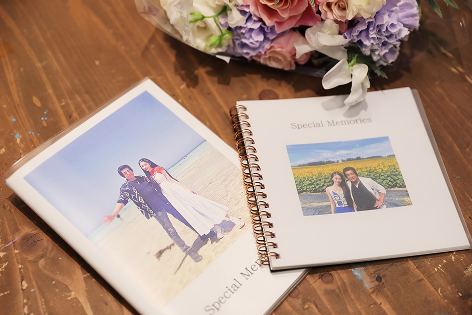 天翔さん親子の写真がプリントされた「PhotoZINE BOOK」と「フォトブック リング」の表紙が並んでいる写真”