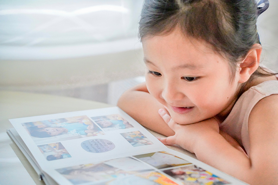 子どもがフォトブックを見ている写真